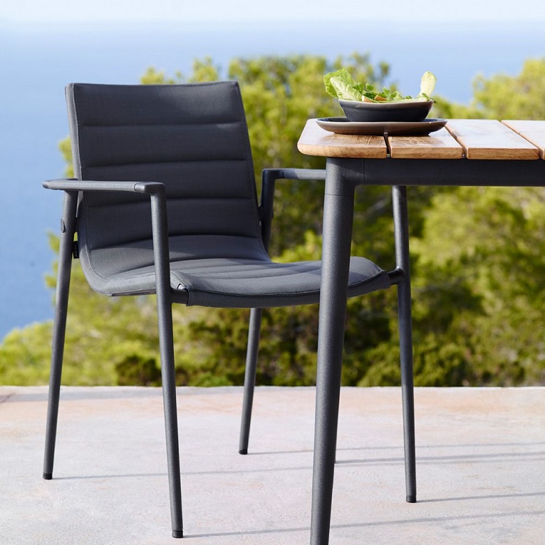 Core dining armchair by Cane-line next to a table