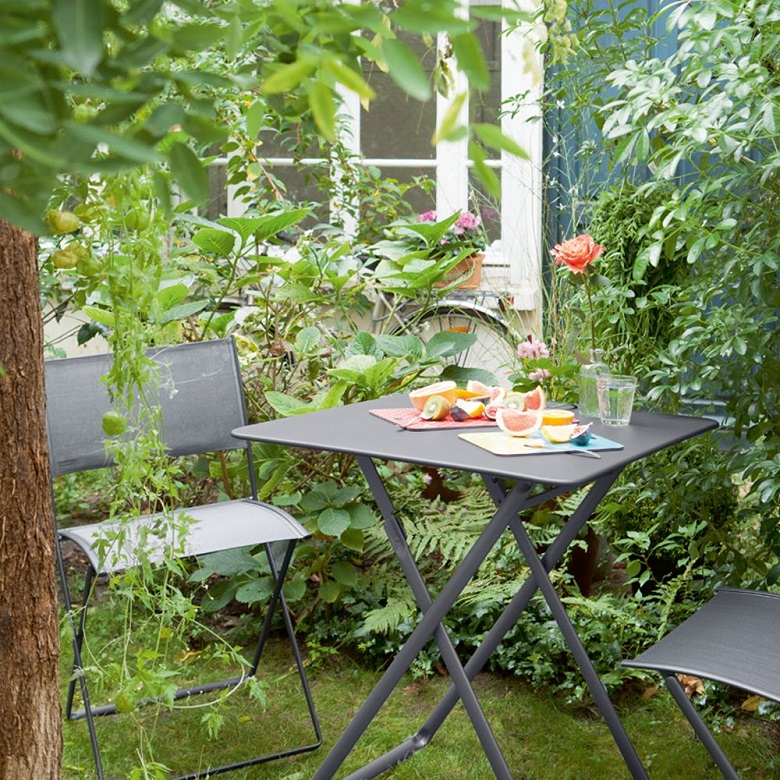 Plein Air table and chairs by Fermob in a garden