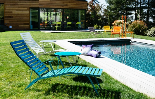 Bistro Chaise Longue sunloungers in a garden next to a swimming pool
