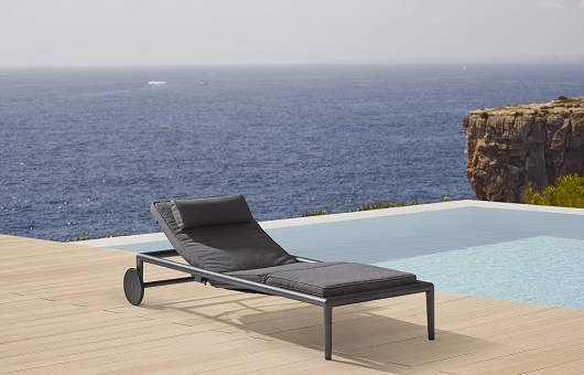Conic outdoor sunbed next to a swimming pool with oceanview in the background